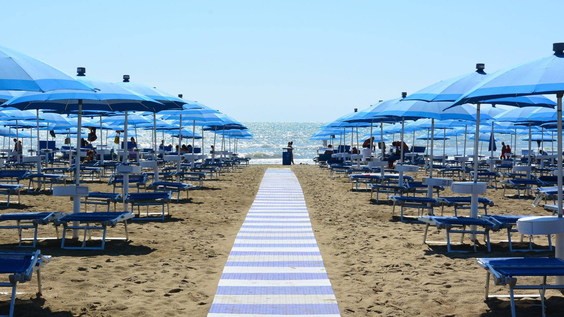 Ombrelloni e lettini sulla spiaggia con il mare azzurro